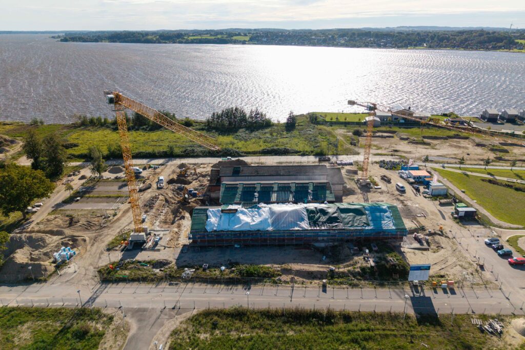 Das Foto zeigt den Baufortschritt der Neuen Freiheit - das Kulturforum, Schleswig aus der Vogelperspektive, im Hintergrund ist die Schlei zu sehen